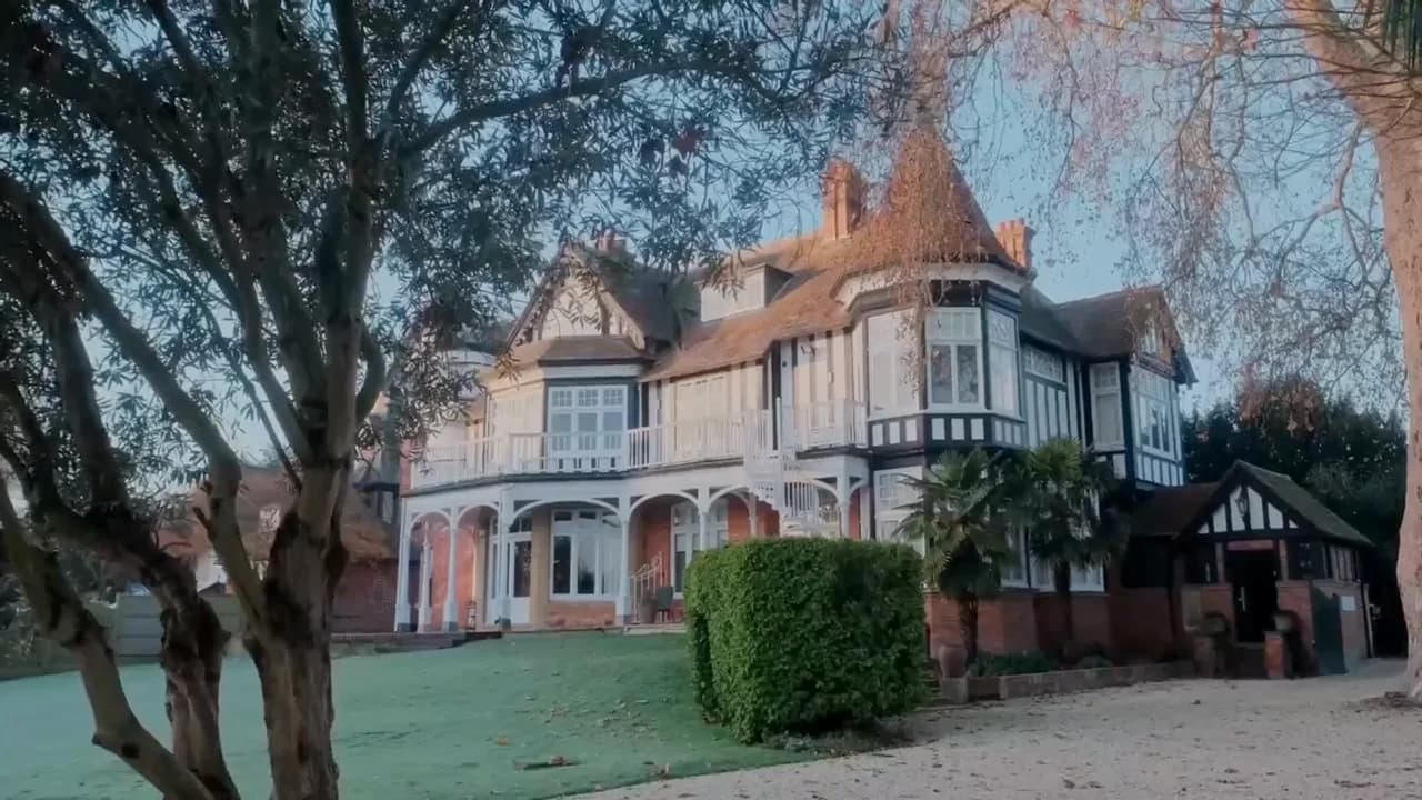 The club's riverside house in daylight, seen across the lawn