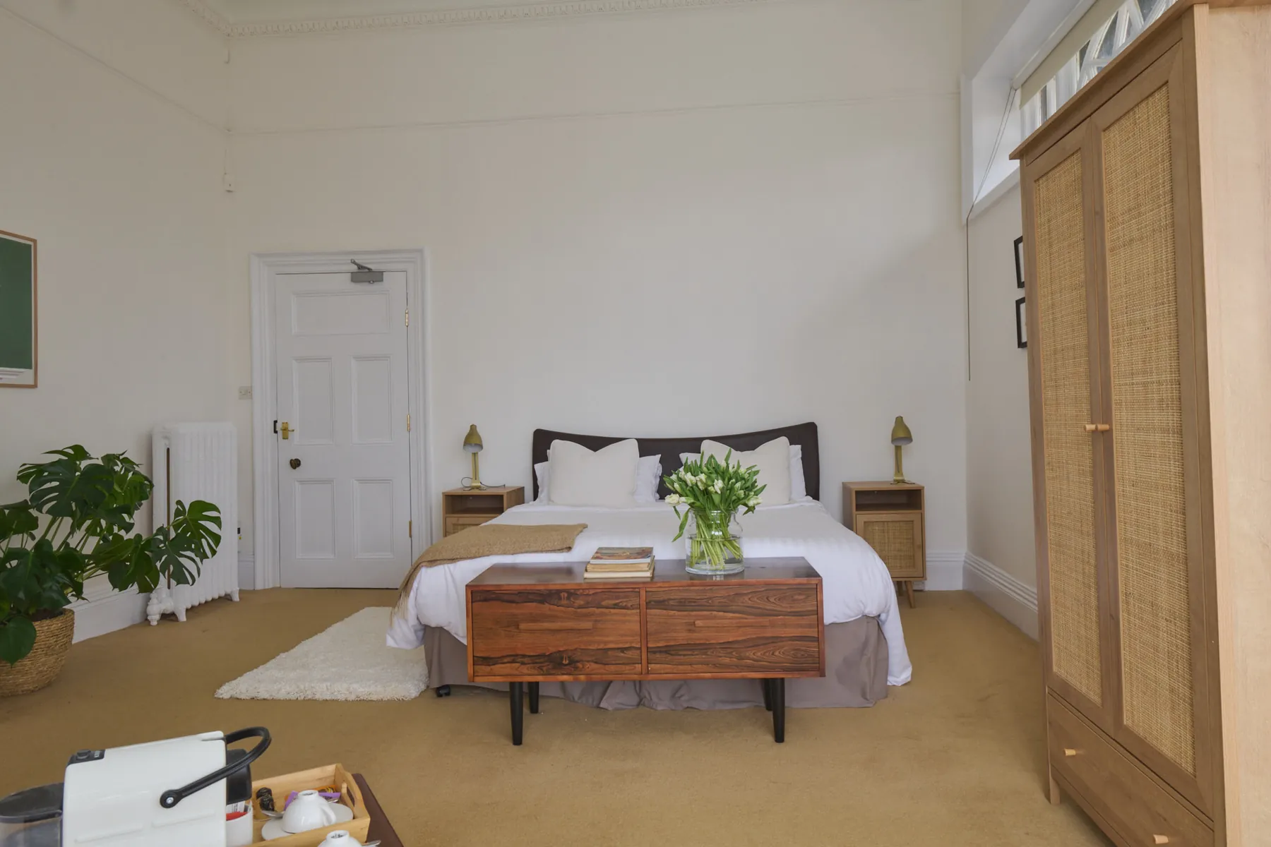 The bed in Brunel's Arch, with tulips on a walnut chest