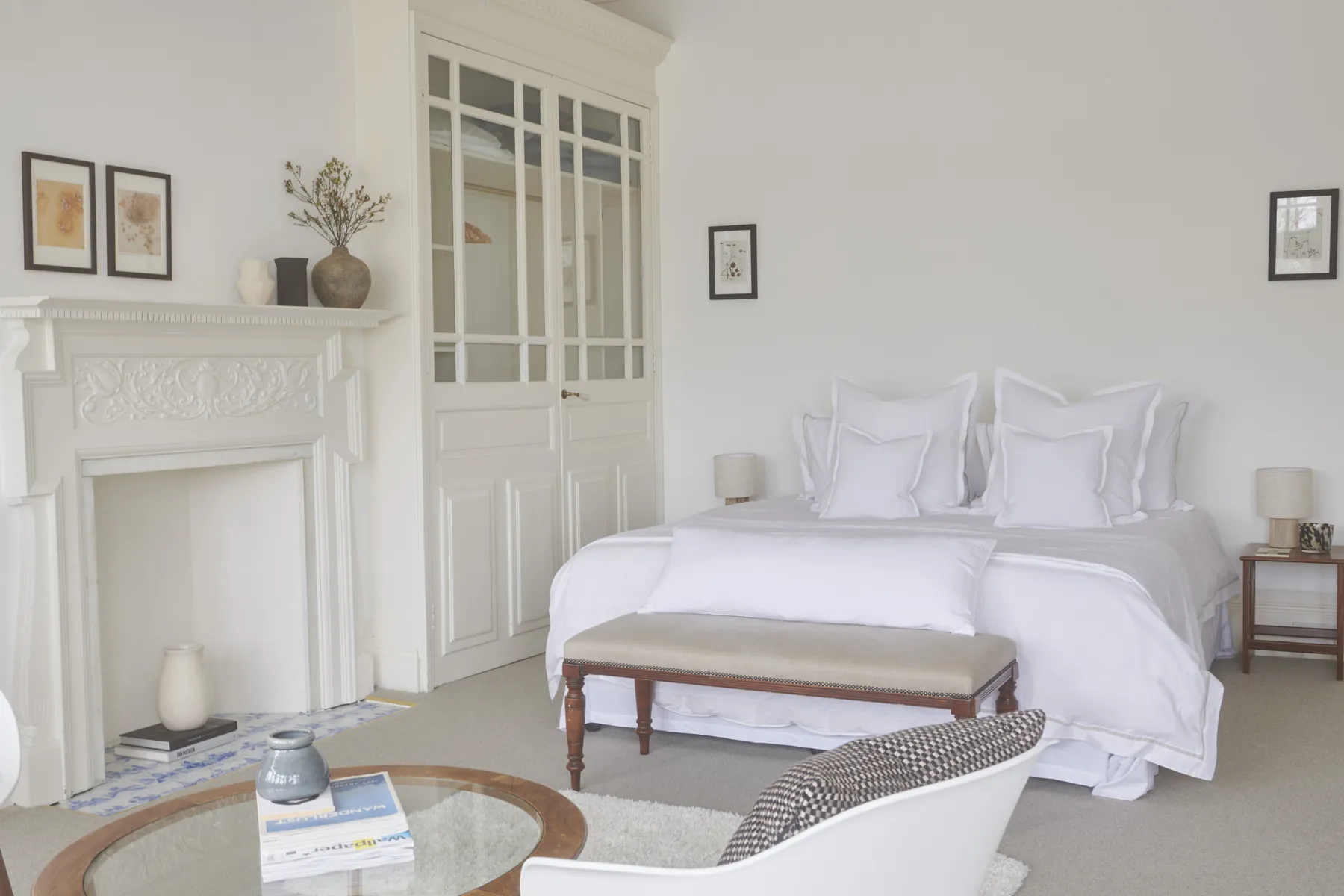 Guards Club, the suite: a super king bed, a pair of armchairs and a round table by the fireplace