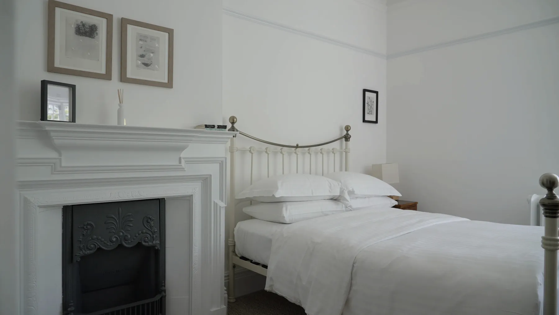 A brass bed and a white fireplace in Nympheas